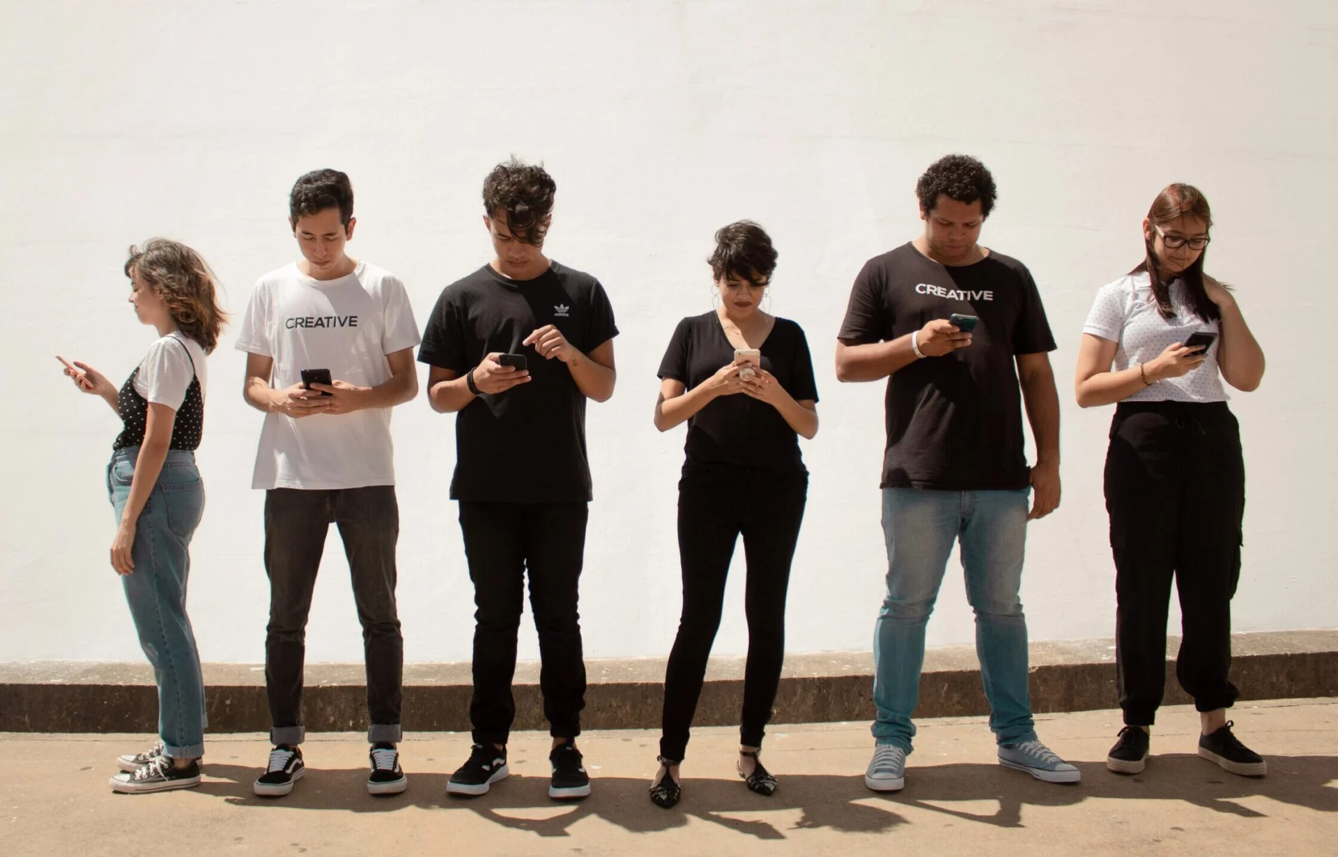 Des jeunes debout qui regardent leurs smartphones